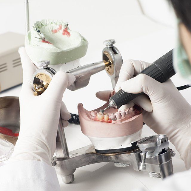 Dental technician working on a denture model